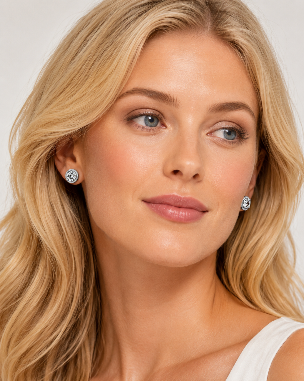 Woman wearing diamond earrings against a neutral background